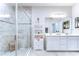 Bright bathroom boasts double sinks, a glass-enclosed shower, and stylish gray tile flooring at 11605 Cleyera Ct, Riverview, FL 33579