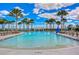 Inviting community pool with palm trees, chairs, and tables offers a tranquil atmosphere at 11605 Cleyera Ct, Riverview, FL 33579