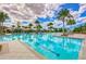 Resort-style community pool surrounded by palm trees, lounge chairs, cabanas, and blue sky, perfect for relaxation at 11605 Cleyera Ct, Riverview, FL 33579