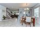 Open dining area with a marble-top table and chairs, seamlessly flowing into the living room and staircase at 11605 Cleyera Ct, Riverview, FL 33579