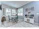 Cozy dining area features a round table with blue chairs, a buffet, and ample natural light from the windows at 11605 Cleyera Ct, Riverview, FL 33579