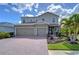Beautiful two-story home with a three-car garage, manicured landscaping and a brick paver driveway at 11605 Cleyera Ct, Riverview, FL 33579