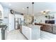 Open-concept kitchen showcases a granite island, stainless steel appliances, and seamless flow into the living area and staircase at 11605 Cleyera Ct, Riverview, FL 33579