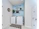 Charming laundry room featuring a laundry-themed wall graphic, shelving and storage cabinet at 11605 Cleyera Ct, Riverview, FL 33579