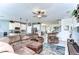 Spacious living room with a sectional sofa, ceiling fan, and an open design leading to the kitchen and dining area at 11605 Cleyera Ct, Riverview, FL 33579