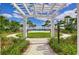 Pathway pergola overlooks the community pool with tropical landscaping at 11605 Cleyera Ct, Riverview, FL 33579