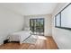 Sunlit bedroom features a balcony with a view of trees and a hardwood floor at 11706 Raintree Village Blvd # D, Temple Terrace, FL 33617