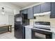 Open kitchen with painted cabinets and black appliances, next to a dining area at 11706 Raintree Village Blvd # D, Temple Terrace, FL 33617