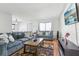 Spacious living room with laminate flooring, blue sofas, area rug, wall-mounted TV, and lots of natural light at 11706 Raintree Village Blvd # D, Temple Terrace, FL 33617