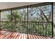 Screened in porch with a view of dense woods from a hardwood floor at 11706 Raintree Village Blvd # D, Temple Terrace, FL 33617