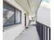 Exterior walkway view with black metal railings leads to a red condo door, offering seamless access to the unit at 11706 Raintree Village Blvd # D, Temple Terrace, FL 33617