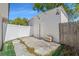 View of the backyard featuring a concrete patio, white fence, and exterior door at 1214 Windsor Cir, Brandon, FL 33510