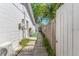 A narrow side yard with pavers and lawn leading to a wooden gate at 1214 Windsor Cir, Brandon, FL 33510