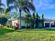 Well maintained home with lush landscaping, including palm trees and colorful plants and an attached garage at 1505 Ventana Dr, Sun City Center, FL 33573