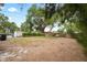 Large, unfenced backyard featuring a large shady tree and greenery in a residential area at 1515 14Th S St, St Petersburg, FL 33705