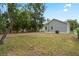 Spacious backyard with grassy and bare areas and the home's gray vinyl siding at 1515 14Th S St, St Petersburg, FL 33705