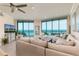 Bright living room with floor-to-ceiling windows offering stunning ocean views and comfortable neutral furnishings at 1560 Gulf Blvd # 502, Clearwater Beach, FL 33767