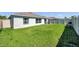 A fenced backyard features well maintained green grass, a grill, and some lawn furniture at 1615 Redmond Brook Ln, Ruskin, FL 33570
