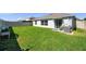 Well-maintained backyard featuring lush green grass, fence, sliding glass door, and patio furniture at 1615 Redmond Brook Ln, Ruskin, FL 33570