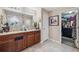 Bathroom with double vanity, framed mirror, walk-in shower, and open closet at 1615 Redmond Brook Ln, Ruskin, FL 33570