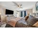 Comfortable bedroom featuring a ceiling fan, tv, dresser, and natural light from the window at 1615 Redmond Brook Ln, Ruskin, FL 33570