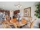 Dining room featuring a classic wooden table, chandelier, and connection to the kitchen area at 1615 Redmond Brook Ln, Ruskin, FL 33570