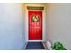 Charming front door adorned with a colorful floral wreath and a welcoming dog statue at 1615 Redmond Brook Ln, Ruskin, FL 33570