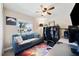 Comfortable office space with a blue couch, ceiling fan, bookshelf, and desk at 1615 Redmond Brook Ln, Ruskin, FL 33570