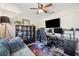 Comfortable office space with a couch, ceiling fan, bookshelf, and desk with monitors at 1615 Redmond Brook Ln, Ruskin, FL 33570