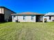 Well maintained backyard with healthy green grass and a view of the home's back exterior at 1945 Fruitridge St, Brandon, FL 33510