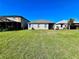 Flat backyard with healthy green grass and a view of the home's back exterior at 1945 Fruitridge St, Brandon, FL 33510