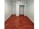 Bedroom with wood-look flooring, a door to the closet, and a white door to the outside at 1945 Fruitridge St, Brandon, FL 33510