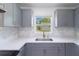 Close up of a gorgeous gray kitchen featuring a stainless steel sink and plenty of cabinet space at 2413 Wishing Well Way, Tampa, FL 33619