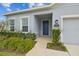 Charming single-story home entrance boasts lush landscaping and a welcoming blue front door and two-car garage at 29241 Rosemallow Rd, Wesley Chapel, FL 33544