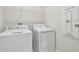 Laundry room with a side-by-side white washer and dryer and wire shelving at 29241 Rosemallow Rd, Wesley Chapel, FL 33544