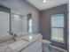This bathroom features a granite countertop vanity with new faucet and framed mirror, plus a walk-in shower at 2988 Pinewood Run, Palm Harbor, FL 34684