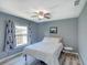 This bedroom features a double bed, hardwood floors, and a ceiling fan, plus a window for natural light at 2988 Pinewood Run, Palm Harbor, FL 34684