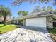 Charming home with a well-maintained garage, driveway, and lush landscaping at 2988 Pinewood Run, Palm Harbor, FL 34684