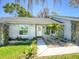 Inviting home entrance with a white front door and decorative landscaping at 2988 Pinewood Run, Palm Harbor, FL 34684