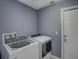 The laundry room features a modern washer and dryer, plus a door for quick access to the home at 2988 Pinewood Run, Palm Harbor, FL 34684