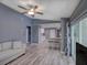 Spacious living room with open layout, gray walls, and access to the kitchen and outdoor area at 2988 Pinewood Run, Palm Harbor, FL 34684