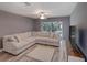 Bright living room featuring a large sectional sofa and sliding doors to the backyard at 2988 Pinewood Run, Palm Harbor, FL 34684