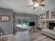 Bright living room features a pool view, fireplace, built-in shelving, and comfortable seating at 2988 Pinewood Run, Palm Harbor, FL 34684