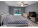 Comfortable main bedroom features ceiling fan, natural light, neutral decor, and outdoor pool access at 2988 Pinewood Run, Palm Harbor, FL 34684