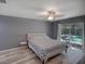 Serene main bedroom features a ceiling fan, pool access through sliding doors, and neutral decor at 2988 Pinewood Run, Palm Harbor, FL 34684