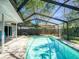 Inviting screened-in pool surrounded by brick pavers providing a serene backyard oasis at 2988 Pinewood Run, Palm Harbor, FL 34684