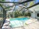 Refreshing screened-in pool with brick pavers and lush green surroundings at 2988 Pinewood Run, Palm Harbor, FL 34684