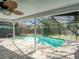 Screened-in pool area with brick pavers and fan offering a relaxing outdoor retreat at 2988 Pinewood Run, Palm Harbor, FL 34684