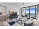 Open-concept living room with modern furniture, a sleek entertainment center, and gorgeous water views at 301 1St S St # 1201, St Petersburg, FL 33701