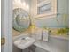 Charming powder room featuring a coastal-themed mural, decorative mirror, and pedestal sink at 3041 Dominion Ct, Safety Harbor, FL 34695